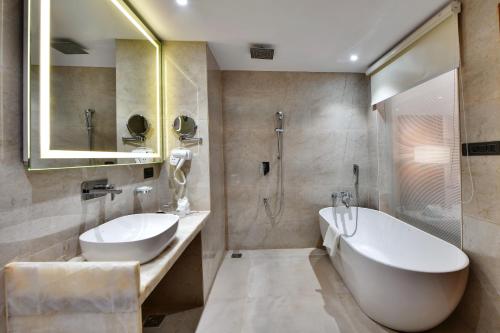 bagno con vasca, lavandino e doccia di The Fern Residency Ajmer a Ajmer