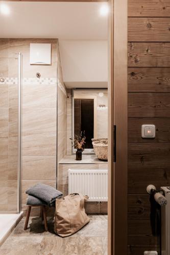 a bathroom with a walk in shower and a sink at Berggasthaus & Lodge Resterhöhe in Mittersill