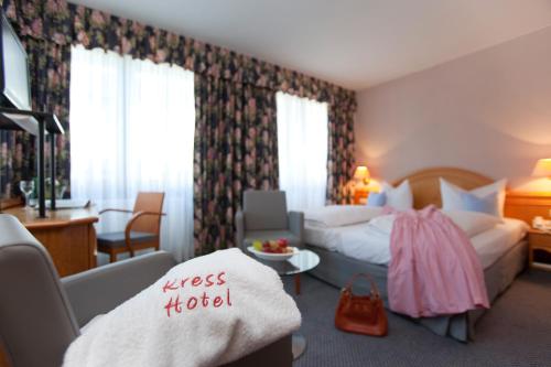 バート・ゾーデン・ザルミュンスターにあるKress Hotelのベッドとシッティングエリアが備わるホテルルームです。