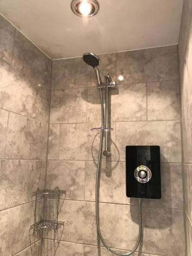 a shower with a shower head in a bathroom at Forestry Cottage. Hot tub, open fire, dog friendly in Gaywood