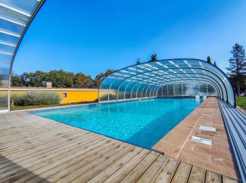 a swimming pool with a glass bridge over a wooden deck at Poggio Imperiale Marche - Apartments & Glamping & Bubble Rooms in Civitanova Marche