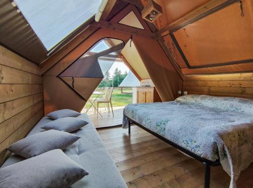 チヴィタノーヴァ・マルケにあるPoggio Imperiale Marche - Apartments & Glamping & Bubble Roomsのベッドと大きな窓のある寝室