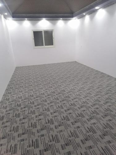 a room with a white wall and a carpet at استراحه لوسيل in Khamis Mushayt