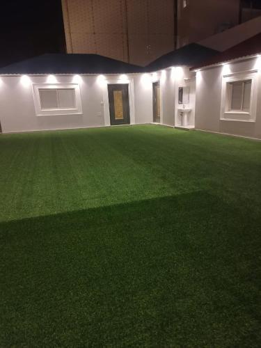 a large field of grass in a building with lights at استراحه لوسيل in Khamis Mushayt