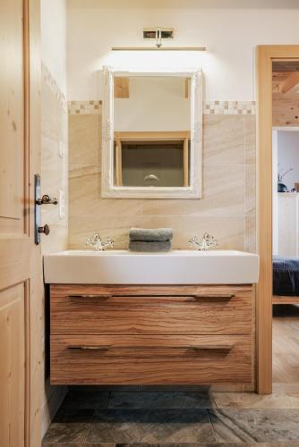 a bathroom with a sink and a mirror at Berggasthaus & Lodge Resterhöhe in Mittersill