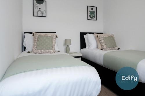 two beds sitting next to each other in a bedroom at Modernised House Close To City Centre in Southampton