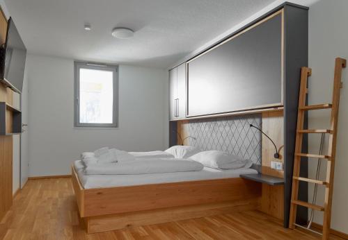 a bedroom with a bed and a ladder in it at Zapfig Living Arlberg in Wald am Arlberg