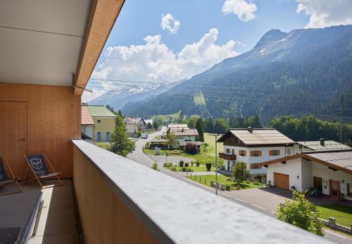 a balcony with a view of a town and mountains at Zapfig Living Arlberg in Wald am Arlberg