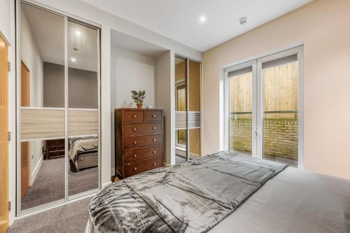 a bedroom with a bed and a dresser and a window at Large Modern One Bedroom Apartment (nearly 800 ft) in London