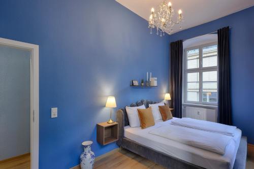 Dormitorio azul con cama y ventana en Balthasar Neumann Apartment - by homekeepers, en Würzburg
