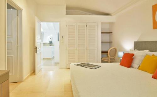 - une chambre dotée d'un lit blanc avec des oreillers orange et jaune dans l'établissement Saint Barth Villa 1, à Saint-Jean