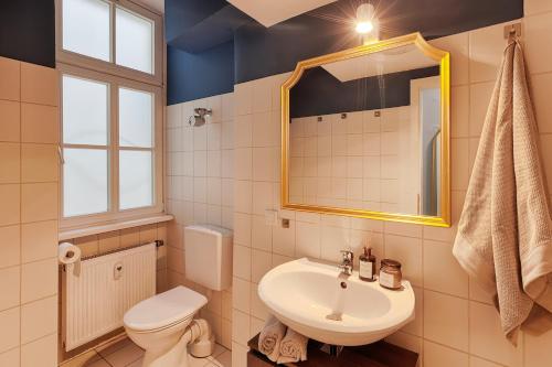 y baño con lavabo, aseo y espejo. en Balthasar Neumann Apartment - by homekeepers, en Würzburg