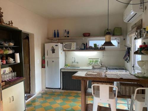 a small kitchen with a table and a refrigerator at Jardín de Niza en Piriápolis - Pedimos 30 porciento anticipado in Piriápolis