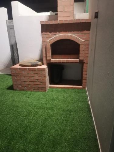 a brick fireplace with green grass in a yard at استراحه لوسيل in Khamis Mushayt