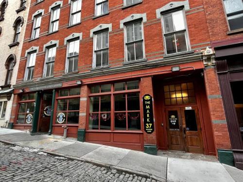 a red brick building with doors on a street at Downtown Albany 1 Bed + Workstation @ Maiden Lane in Albany