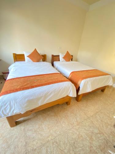 two beds sitting next to each other in a room at Sun Hà Giang Hotel-tours-motorbike rental in Ha Giang