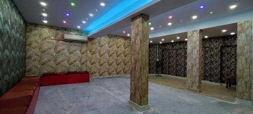 ein großes Zimmer mit einer Bühne und einer Wand mit einem Wandbett in der Unterkunft Tusthi Banquets in Kalkutta