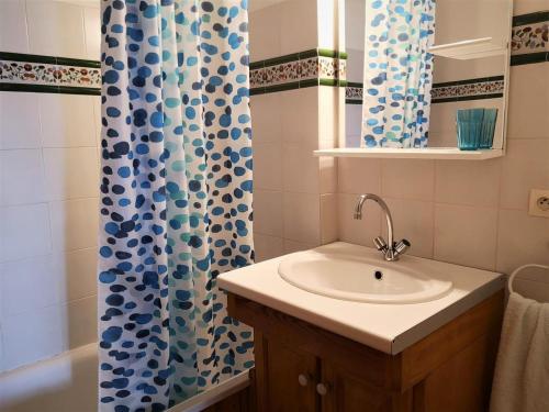une salle de bain avec un lavabo et un rideau de douche dans l'établissement Apartamento en Bolquère II, à Font-Romeu-Odeillo-Via