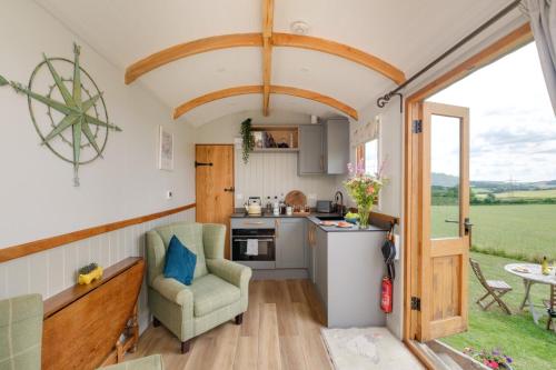 an open kitchen and living room in a tiny house at The Acorn - Luxury Shepherds Hut hot tub panoramic views in Bradpole