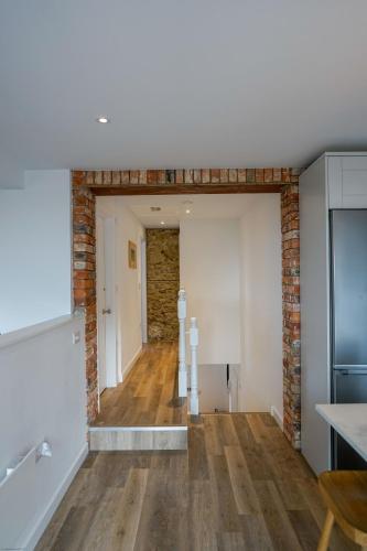 an empty room with a brick wall and a kitchen at Jumble Cottage in Seaview