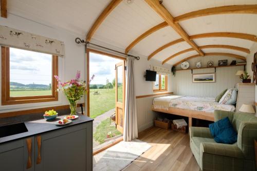 a bedroom in a tiny house with a large window at The Acorn - Luxury Shepherds Hut hot tub panoramic views in Bradpole