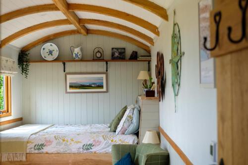 una camera con un letto in una piccola stanza di The Acorn - Luxury Shepherds Hut hot tub panoramic views a Bradpole