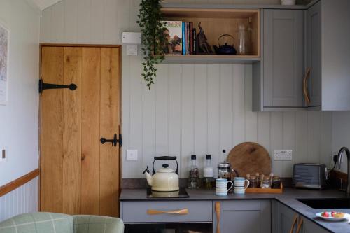 una cucina con bollitore per il tè su un bancone di The Acorn - Luxury Shepherds Hut hot tub panoramic views a Bradpole