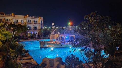 a large swimming pool at night with blue lights at Jungle sweet Home Compound in Hurghada