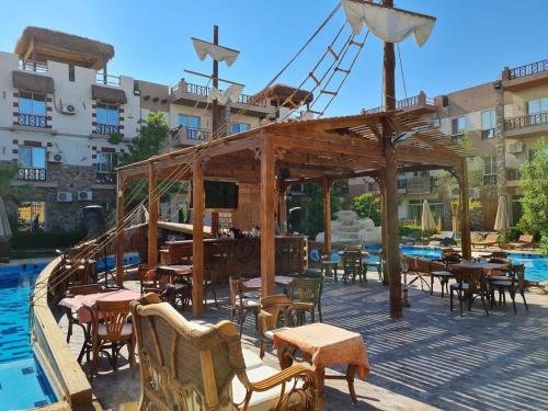 a patio with tables and chairs next to a pool at Jungle sweet Home Compound in Hurghada