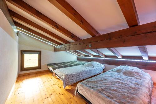 Zimmer im Dachgeschoss mit 2 Betten und einem Fenster in der Unterkunft L'Eglantine - Appt avec mezzanine à la montagne in Crest-Voland