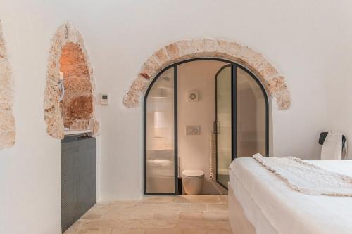 a bedroom with a bed and an arch doorway at Trulli Piovanello in Castellana Grotte