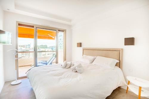 - une chambre avec un grand lit blanc et un balcon dans l'établissement One BDRM flat A/C-Congress/Beaches by Olidesi, à Cannes