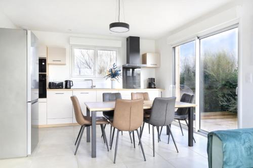 une cuisine et une salle à manger avec une table et des chaises dans l'établissement Chez Marie et Philippe - 1km de la plage, à Les Moitiers-dʼAllonne