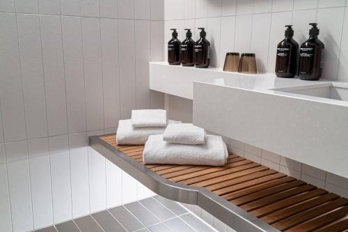 a bathroom with black bottles and towels on a shelf at Nordic Light Hotel in Stockholm