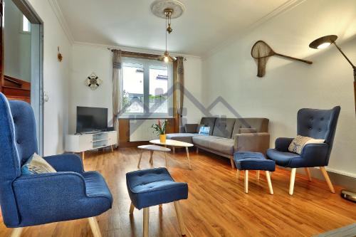 Il comprend un salon doté de fauteuils bleus, d'un canapé et d'une télévision. dans l'établissement LocaLise - M8 - Ty Geoland - Maison à deux pas du centre avec jardin au Guilvinec - Wifi inclus - Animaux bienvenus- Linge de lit inclus, au Guilvinec