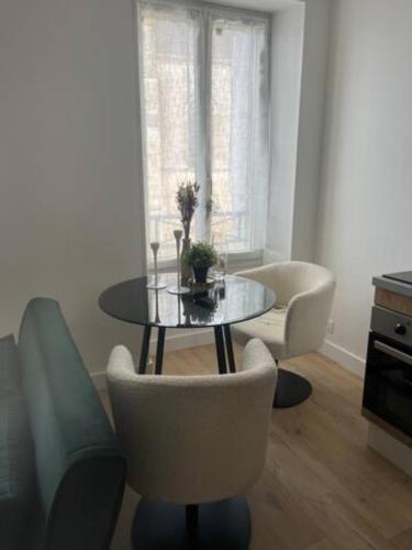 a living room with a glass table and chairs at Charmant T2 - Plein centre ville in Niort