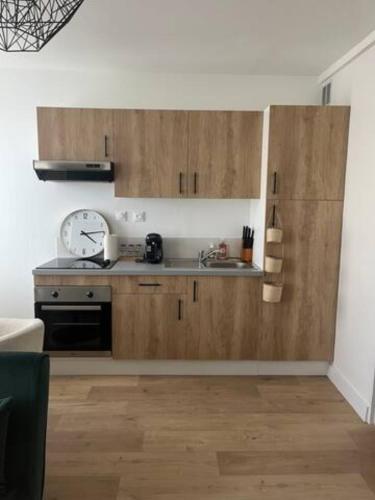 une cuisine avec des armoires en bois et un évier dans l'établissement Charmant T2 - Plein centre ville, à Niort