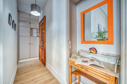 pasillo con espejo de color naranja y escritorio de madera en La Belle Gare, en Grenoble