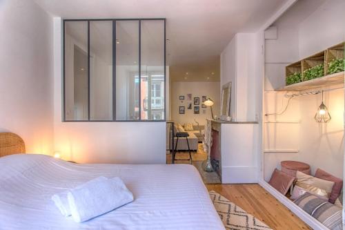 a bedroom with a large bed and a living room at Le rendezvous des grenoblois in Grenoble