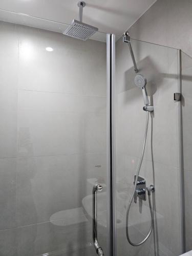 La salle de bains est pourvue d'une douche avec une porte en verre. dans l'établissement 1721 Aeon Towers 1 Bedroom Condo with Free Wifi & Netflix, à Davao