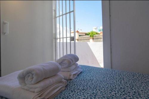 uma pilha de toalhas sentadas em cima de uma cama em BaÑos - Casa Sevillana em Sevilha
