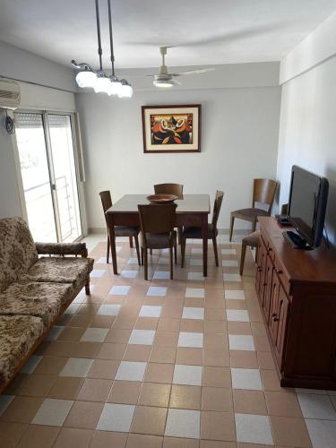 a living room with a table and a couch and a tv at Amplio Departamento en el corazón de Paraná in Paraná