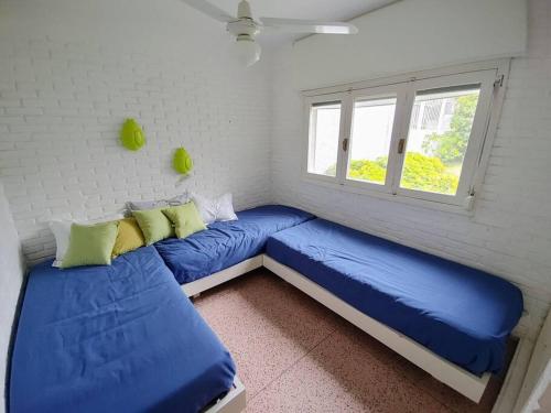 um quarto com duas camas azuis e uma janela em Nirvana em Punta del Este