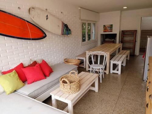 uma sala de estar com um sofá e uma prancha de surf na parede em Nirvana em Punta del Este