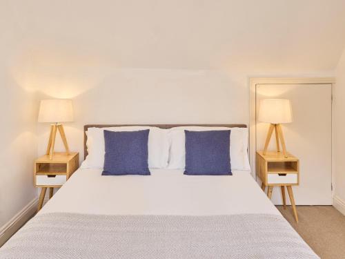 a bedroom with a white bed with blue pillows at Host & Stay - Queen's Corner in Canterbury