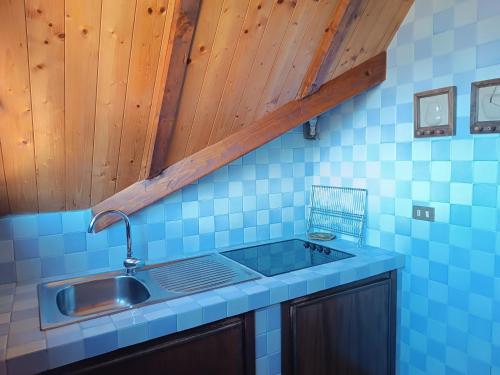 una cucina con lavandino e parete piastrellata blu di Chiara Loft a Stresa