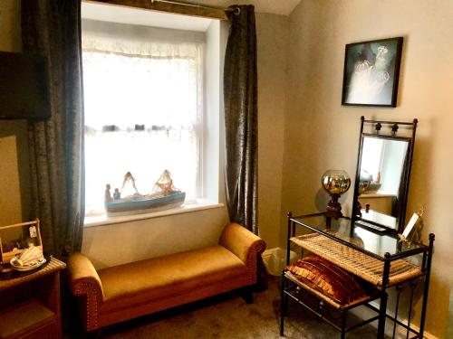 a living room with a bench and a window at Mulberry House in Llandudno