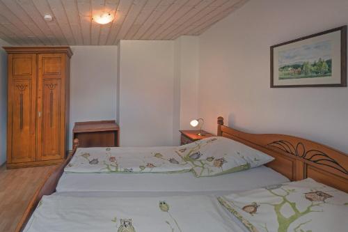 a bedroom with two beds and a wooden headboard at Schelterhof in Wunsiedel