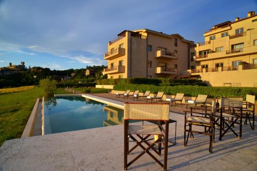 a group of chairs and a table next to a pool at Fonteliving in San Casciano dei Bagni