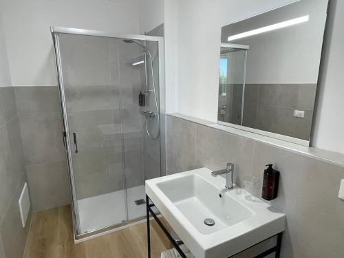a bathroom with a shower and a sink and a mirror at Borgo Terra village in Fagagna